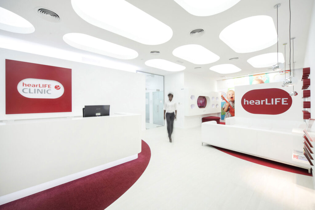 Moderne, helle Empfangshalle mit weißem Interieur und roten Akzenten.