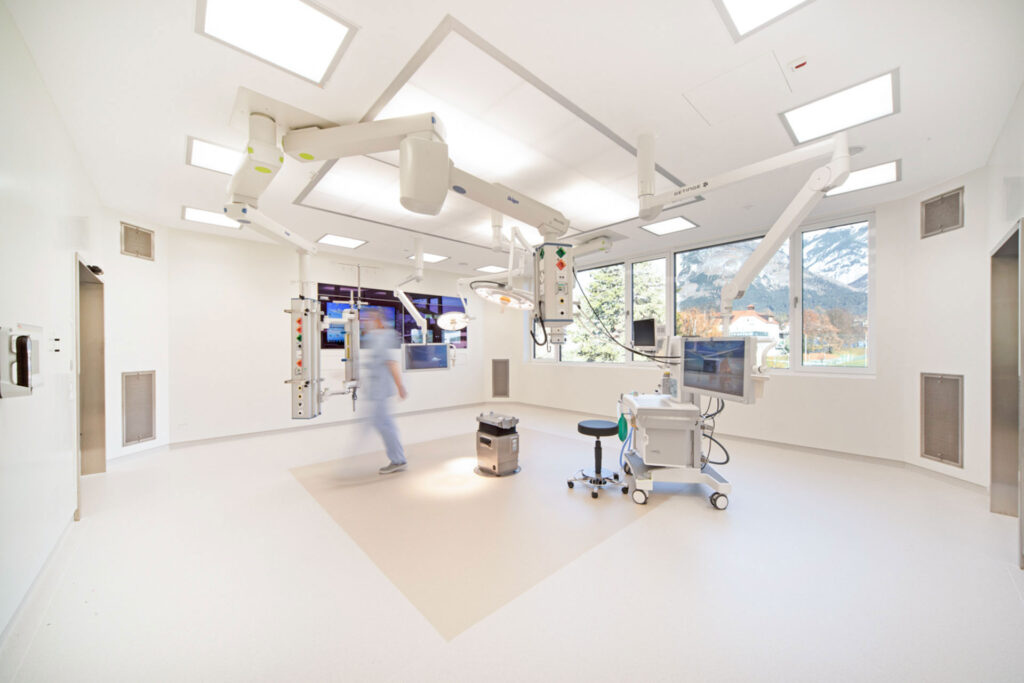 Moderner OP-Saal mit medizinischer Ausstattung und großem Fenster.