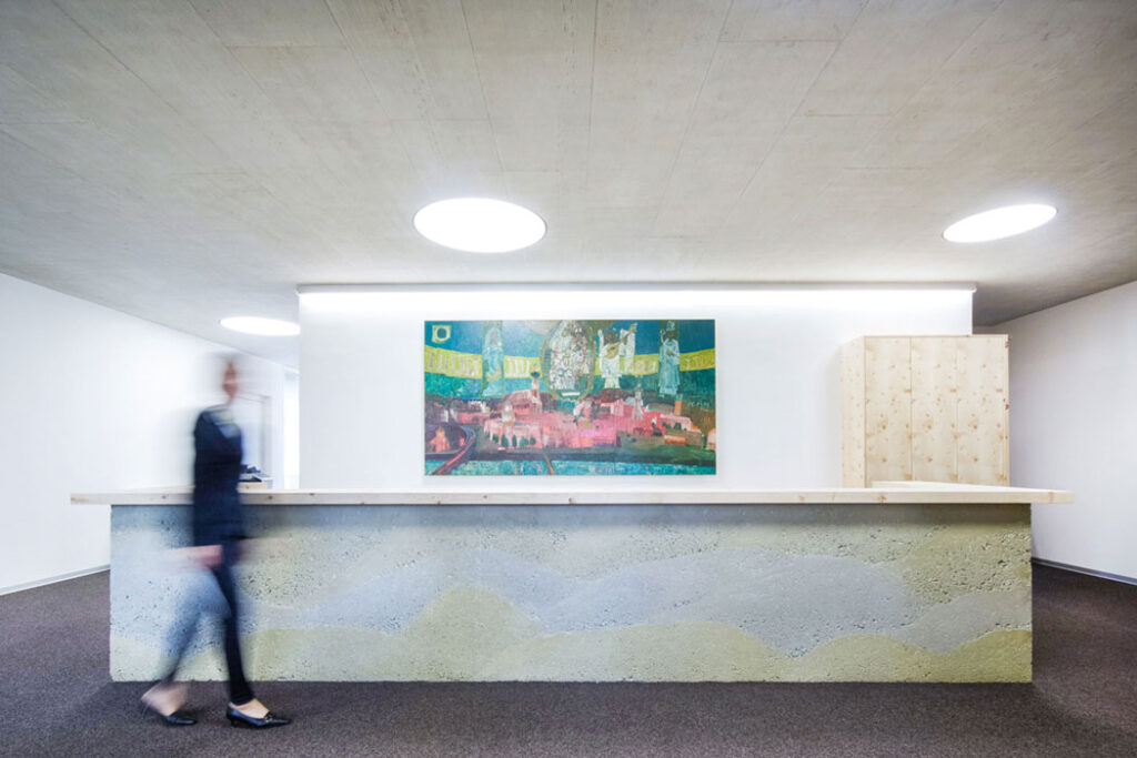 Heller Empfangsbereich mit großem farbenfrohem Kunstwerk und reduzierter Gestaltung.