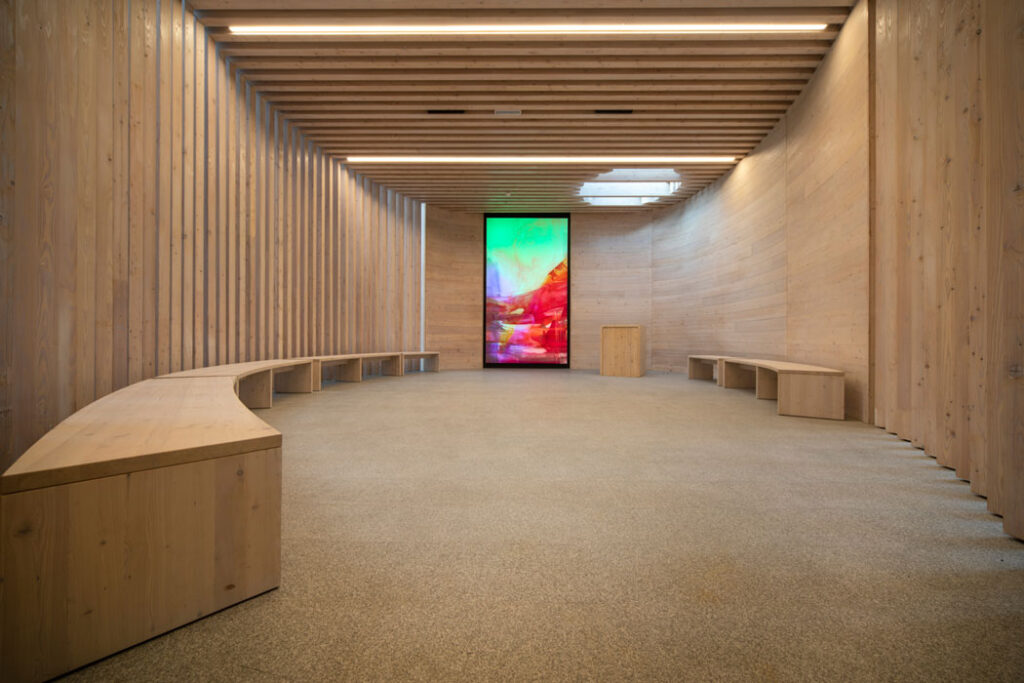 Meditativer Raum aus Holz mit Lichtöffnung und Kunst