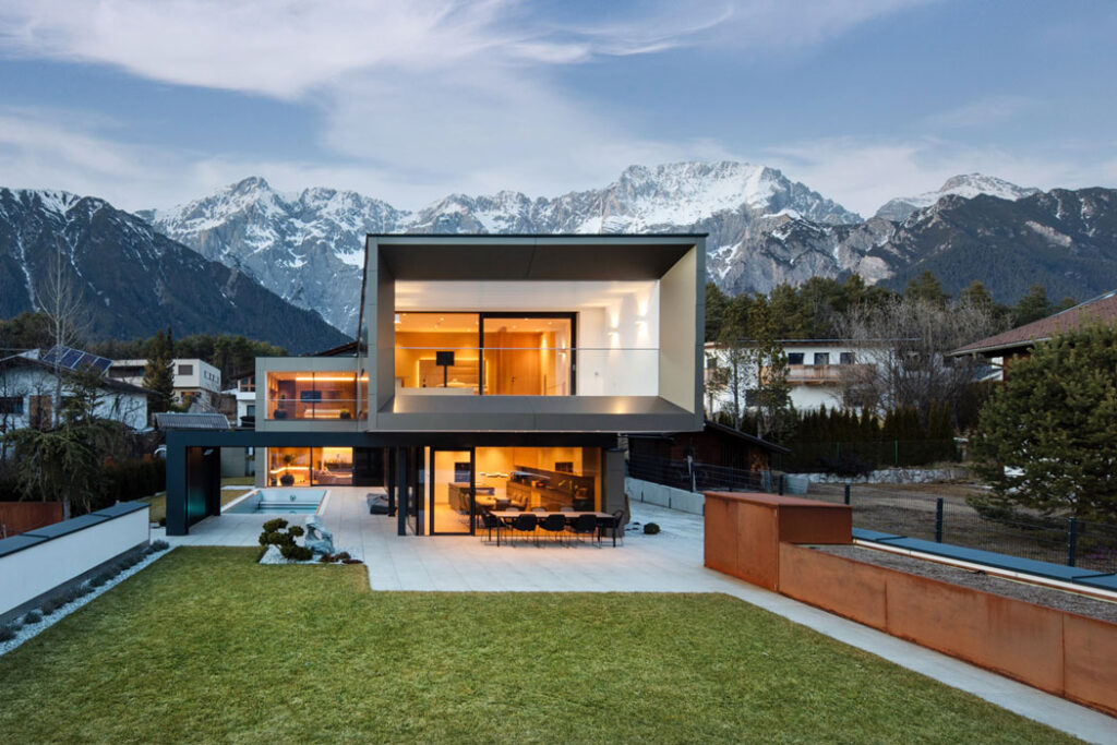 Modernes Wohnhaus mit Bergkulisse und großzügiger Glasfassade