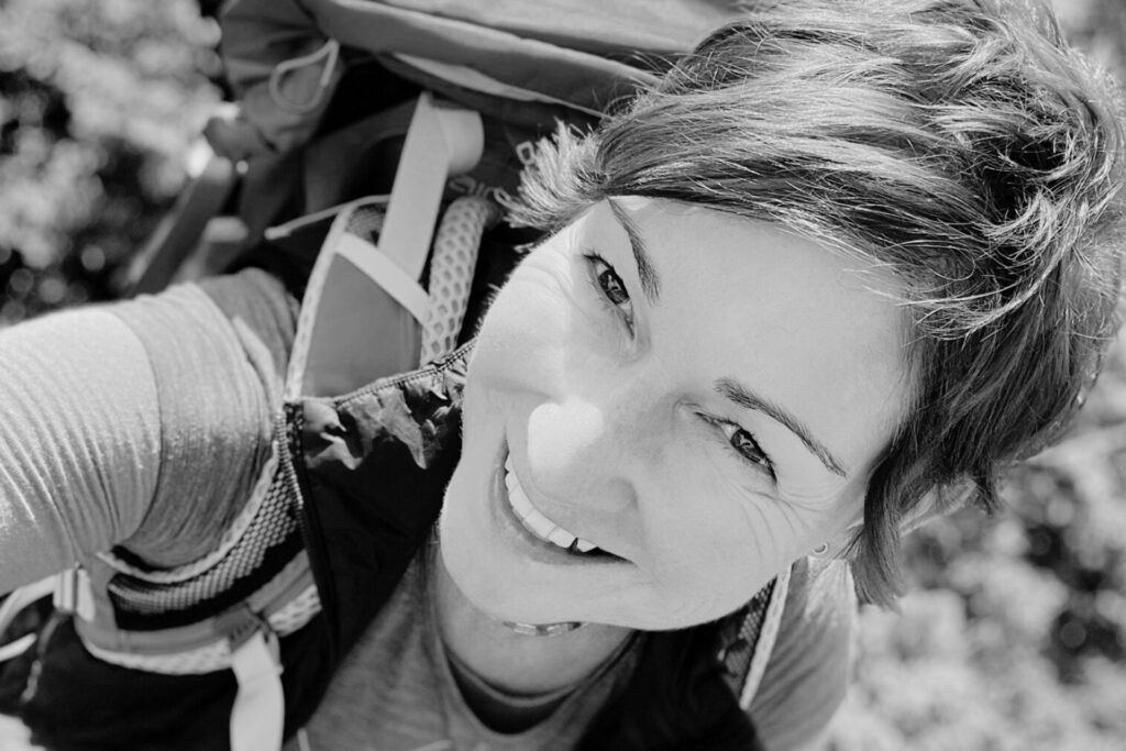 Frau mit Rucksack lächelt in die Kamera