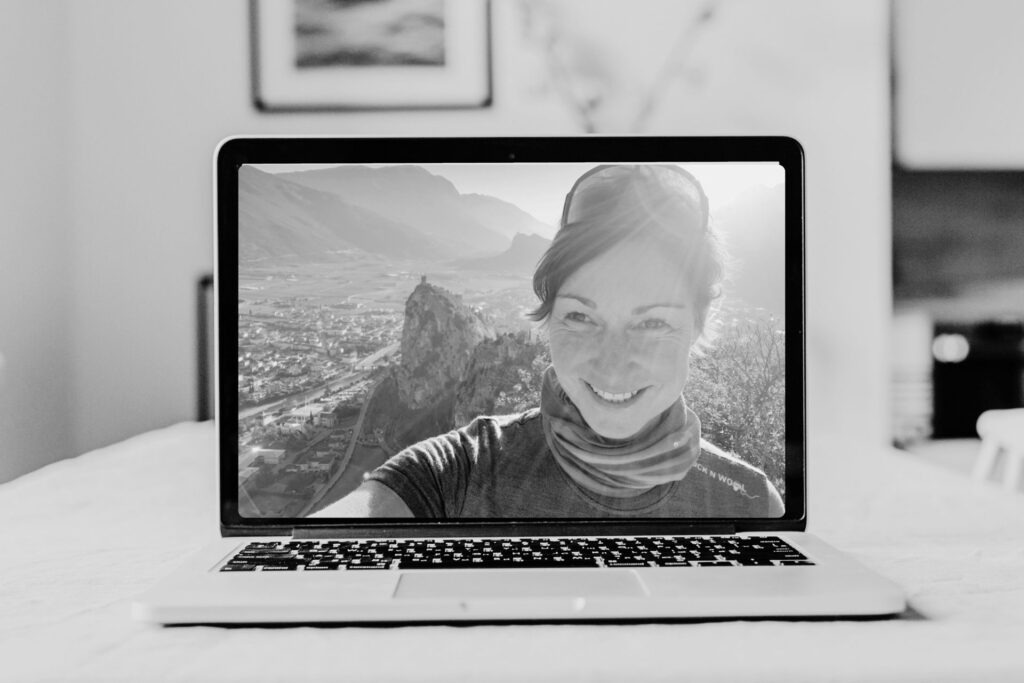 Frau mit Landschaft im Laptopbildschirm sichtbar