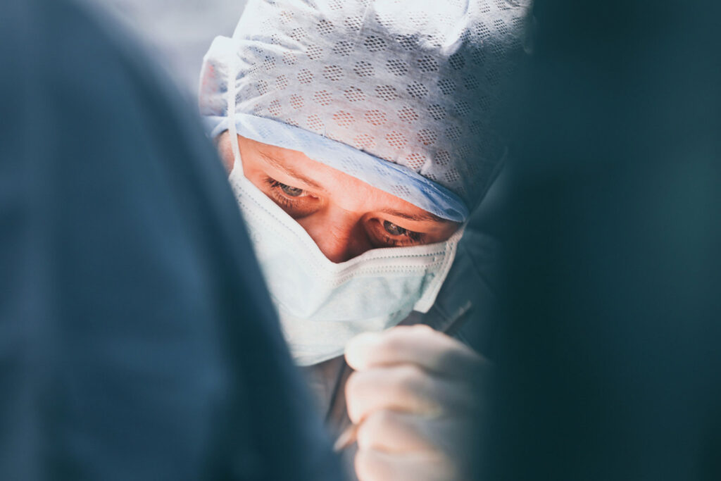 Chirurg*in konzentriert während eines medizinischen Eingriffs.